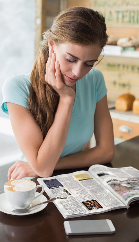 A woman reading Bartlesville Monthly Magazine